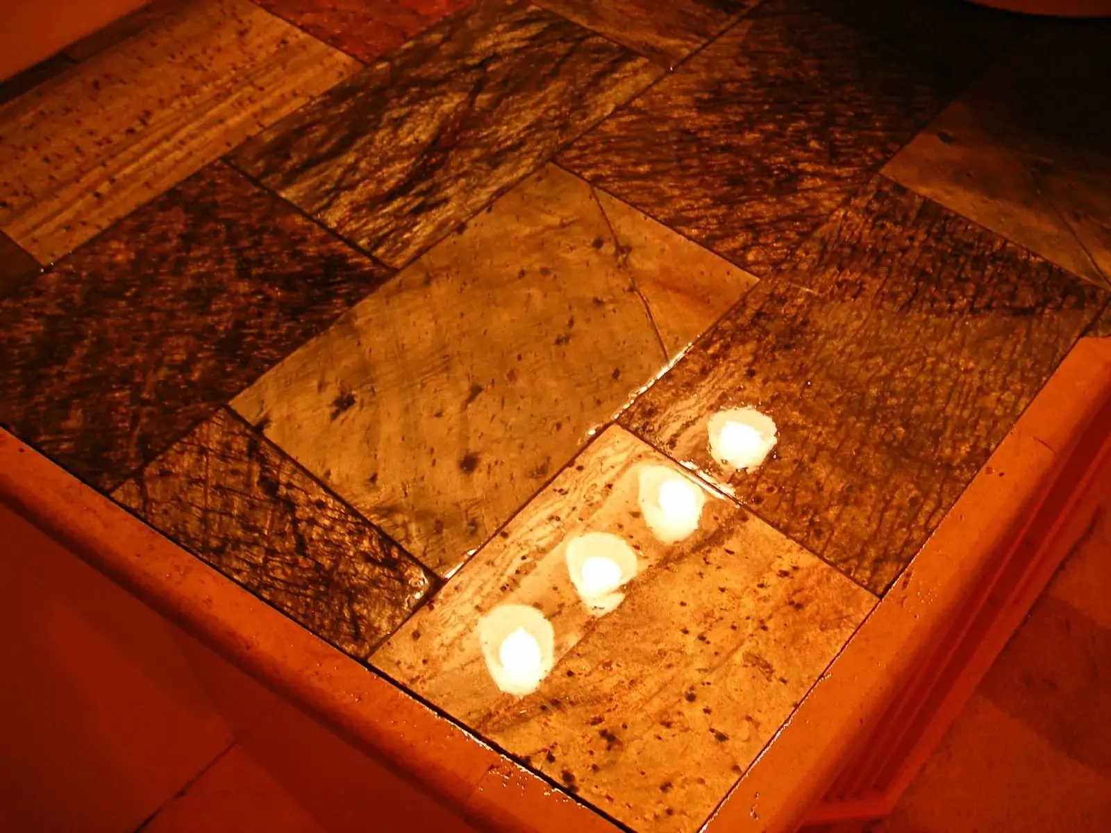 close-up-of-textured-stone-tiles-with-candlelight close-up-of-textured-stone-tiles-with-candlelight